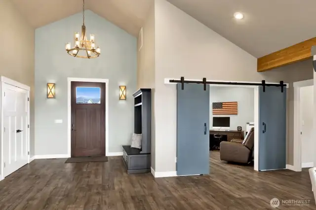 Standing from the living area, an extra wide entryway was designed with the intention of future ADA accessible living if needed. A glimpse into the office/den area with barn doors that amplify the beautiful style of this home.