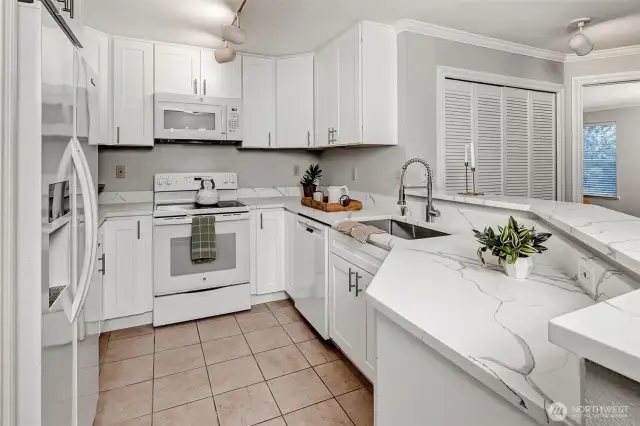 Open kitchen with brand new soft-close cabinets and quartz counter tops