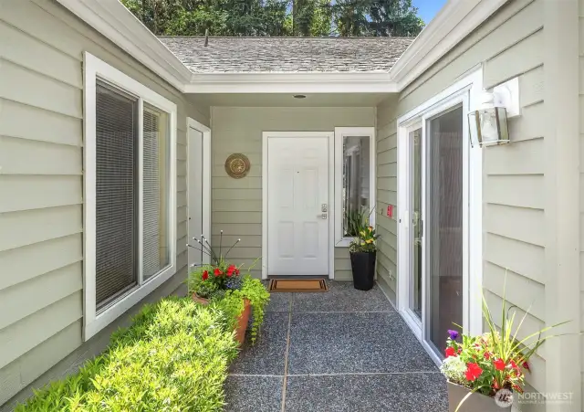Charming entrance with covered walkway to garage.