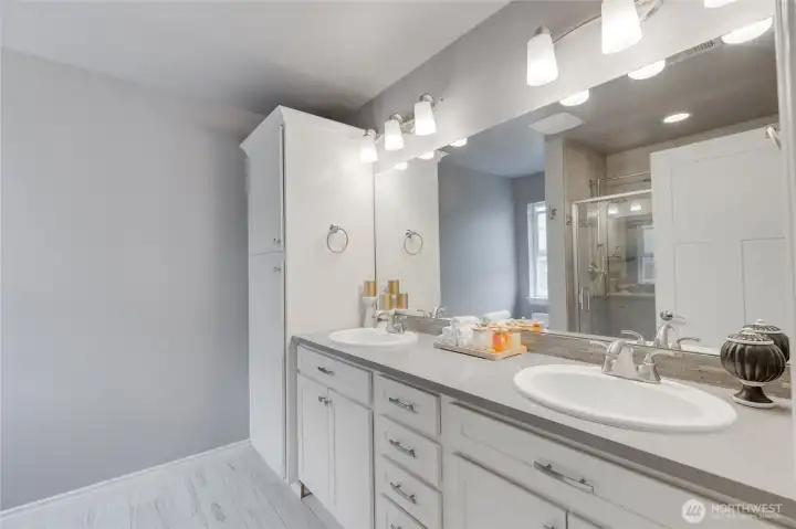 Primary ensuite with two sinks on marble counters.