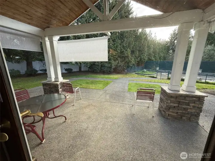 Pleasant covered patio on west side of community center.   Pet area in the distance