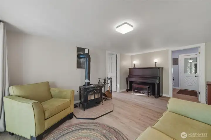 This wood stove currently is the only heat source in the house.  View of laundry room in the background with a door leading you to the garage.