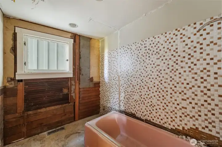 Unfinished bathroom on the main floor between kitchen and laundry room (across from stairs).