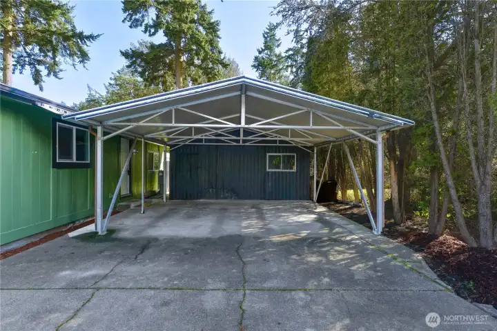 Detached outbuilding and covered carport providing parking and storage