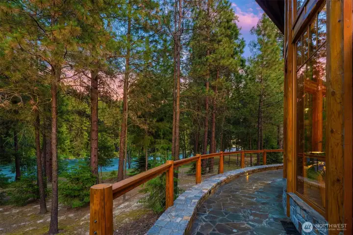 The warm Montana Fir exterior, multiple rooflines, and stone accents blend seamlessly into the natural surroundings, while the scale of the home and grounds highlights the rarity of this secluded Wenatchee River setting.