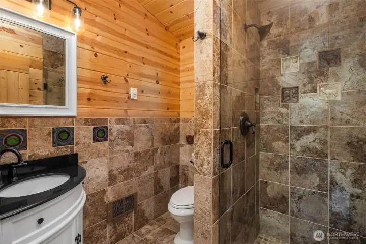 Bath with tiled walk-in shower and warm, rustic finishes.