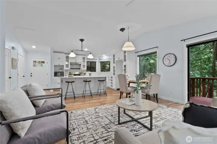 Open living, dining, and kitchen layout with abundant windows