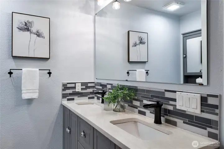 Double vanity bathroom with updated fixtures and tile backsplash