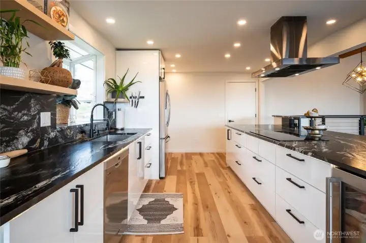 Exemplary kitchen features stainless steel appliances as well as a induction cooktop.