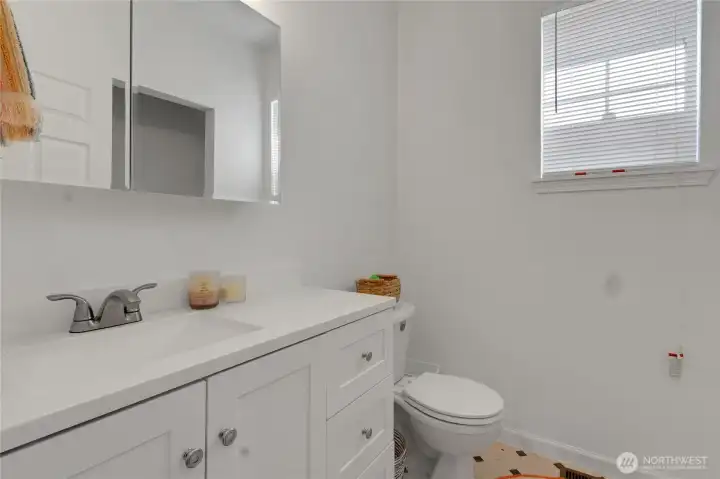 Half bath boasts a new vanity, mirror with storage cabinet and your washer and dryer are in the closet space to the right!