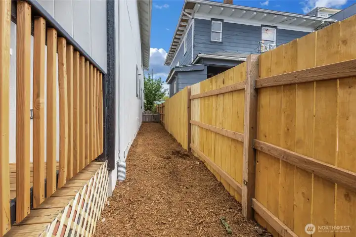 Side yard with freshly laid beauty bark and new cedar fence!