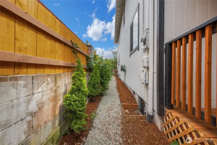 Designated gravel path, freshly laid beauty bark, new cedar fence and trees line your side yard!