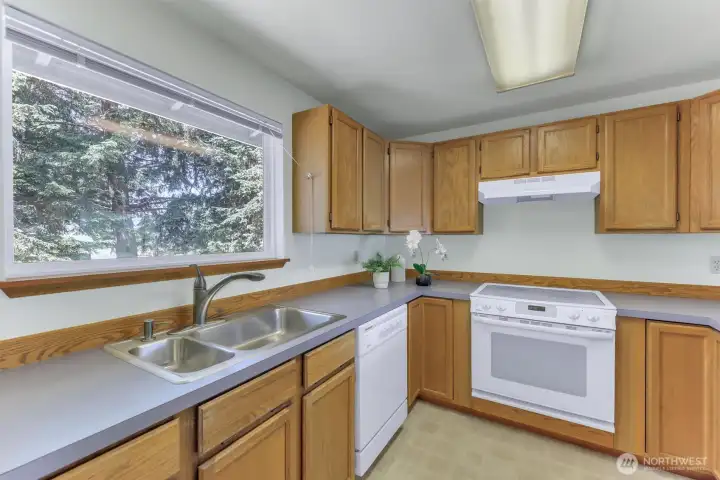 The kitchen features a large window with a view of the private back yard.