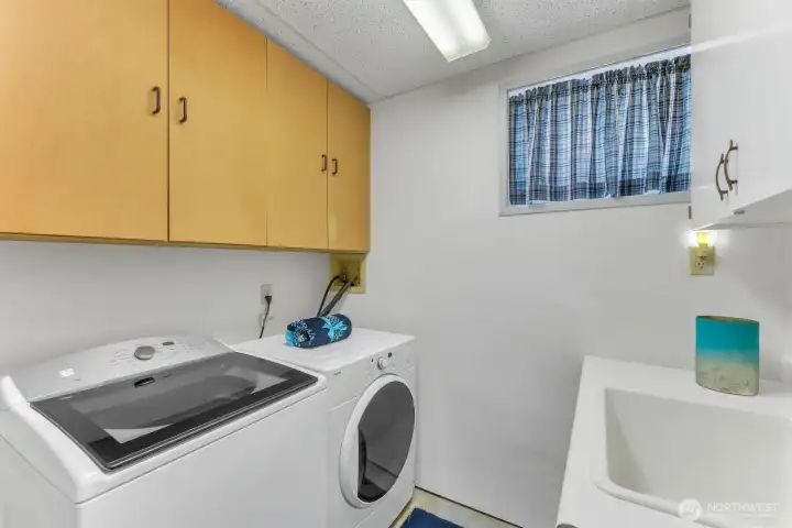 The utility room includes the washer and dryer that stay with the home and a utiltiy sink.