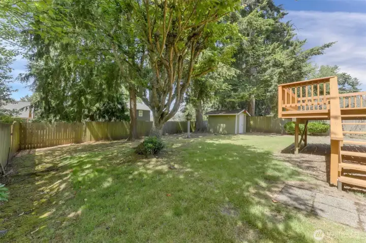 The rear deck is multi-level and opens to a large back yard. Notice the storage shed.