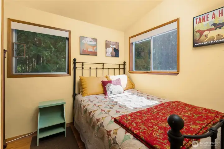 The bedroom is small but mighty! Lots of natural light and easy access to the bathroom around the corner.