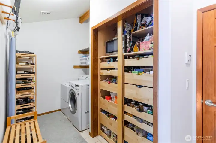 Utility room. Washer and dryer stay with the home. Custom space saving pantry with pull out shelves. Door on left leads to garage. Door on right, leads to the kitchen, making bringing in groceries convenient. Utility room. Washer and dryer stay with the home. Custom space saving pantry with pull out shelves. Door on left leads to garage. Door on right, leads to the kitchen, making bringing in groceries convenient.
