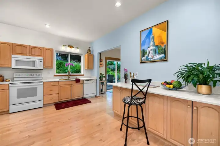The kitchen offers generous workspace, abundant cabinetry, and views into the surrounding gardens from the sink window. Its central location connects easily to the dining area, deck, and main living spaces. The kitchen offers generous workspace, abundant cabinetry, and views into the surrounding gardens from the sink window. Its central location connects easily to the dining area, deck, and main living spaces.