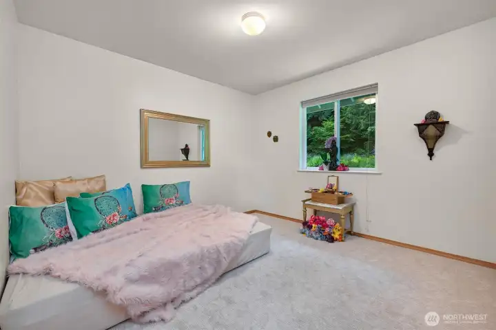 This secondary bedroom on the home's 2nd level offers generous floor space and a large window overlooking the property's gardens and forest. It works equally well as a bedroom, guest room, hobby space, or home office. This secondary bedroom on the home's 2nd level offers generous floor space and a large window overlooking the property's gardens and forest. It works equally well as a bedroom, guest room, hobby space, or home office.