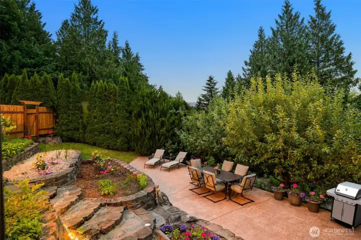 This paved patio serves as one of the property's primary outdoor gathering spaces, surrounded by gardens, mature landscaping, and forest. It's an ideal spot for outdoor dining, morning coffee, or relaxing with friends while enjoying the privacy created by the surrounding greenery. This paved patio serves as one of the property's primary outdoor gathering spaces, surrounded by gardens, mature landscaping, and forest. It's an ideal spot for outdoor dining, morning coffee, or relaxing with friends while enjoying the privacy created by the surrounding greenery.