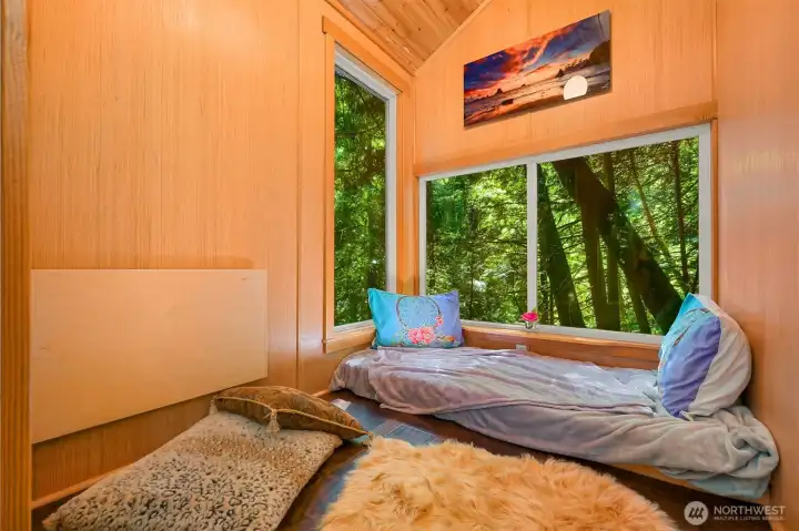Inside, the treehouse feels immersed in the forest, with large windows framing the surrounding trees and natural light. The insulated interior includes a fold-down desk and cozy sitting area, creating a quiet space to read, write, work remotely, or simply enjoy being among the trees. Inside, the treehouse feels immersed in the forest, with large windows framing the surrounding trees and natural light. The insulated interior includes a fold-down desk and cozy sitting area, creating a quiet space to read, write, work remotely, or simply enjoy being among the trees.