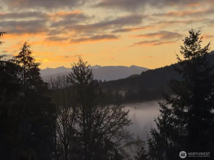 The primary bedroom enjoys views toward the Twin Sisters and the surrounding foothills, with morning light and seasonal fog often creating scenes like this right from the window. It's a reminder that while the property feels tucked away in the forest, it also enjoys a surprising sense of openness and connection to the broader landscape. The primary bedroom enjoys views toward the Twin Sisters and the surrounding foothills, with morning light and seasonal fog often creating scenes like this right from the window. It's a reminder that while the property feels tucked away in the forest, it also enjoys a surprising sense of openness and connection to the broader landscape.