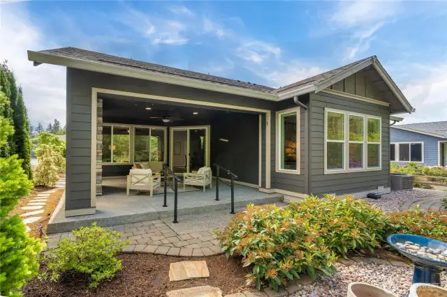 The huge covered porch with handrails down to the beautifully landscaped backyard.  Extensive hardscape along the rear and side yard and beautiful mature plantings.