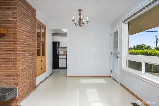 The dining area has large windows to keep it naturally bright. The wall to the left of the door is the kitchen - potential to take it down and open up the flow between the two rooms.
