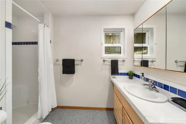 3/4 bath located at the end of the hallway complete with tiled shower and large mirrored medicine cabinet.