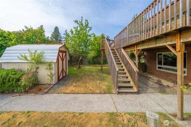 Showing the backyard and deck access. Sidewalk to the back gate where the mailbox is located is in great shape.