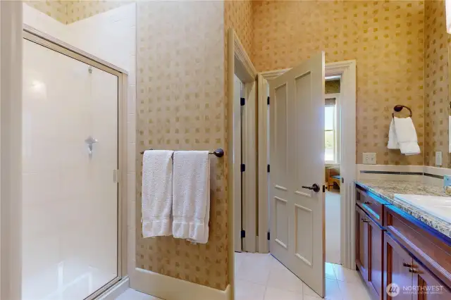 Primary bathroom – tile walk-in shower, granite counter, and direct access to the bedroom.