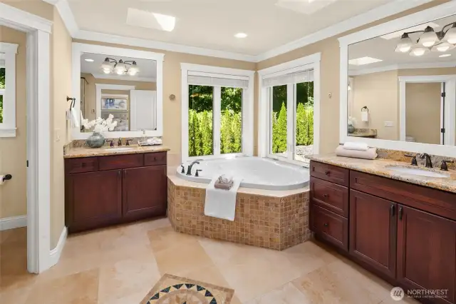Luxurious master spa bath features an extra-large jetted tub and tiled  shower, heated travertine floor, two skylights.