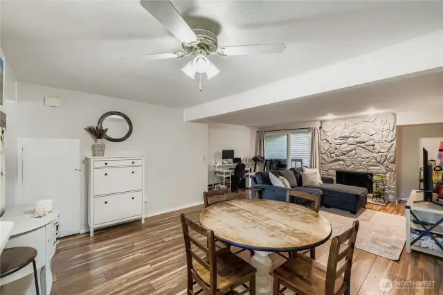 Large dining area opens to living room, wood burning fireplace, and covered back deck