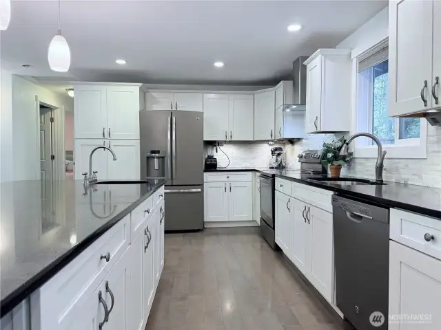 Massive kitchen islan with seating on two sides and black stainless appliances