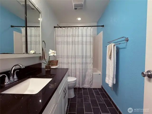 Bathroom with quartz countertop and tile floors