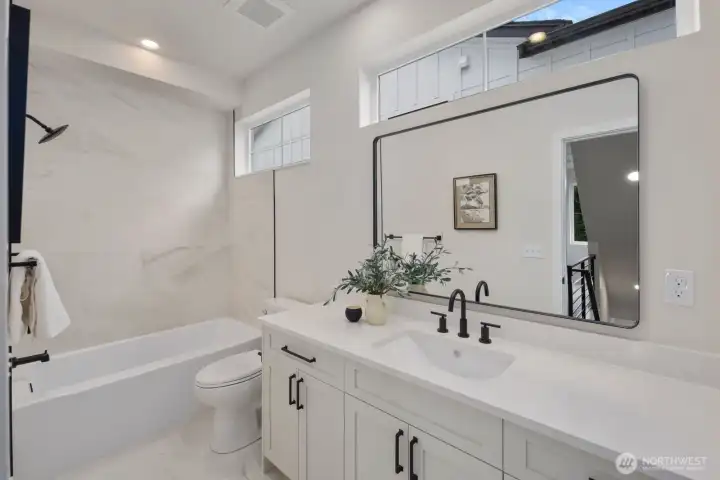 Second floor guest bath with tub/shower combo and natural light coming in from the upper windows in tub area and behind the vanity. Second floor guest bath with tub/shower combo and natural light coming in from the upper windows in tub area and behind the vanity.