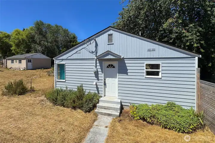Sdie of the home with the garage in the background.