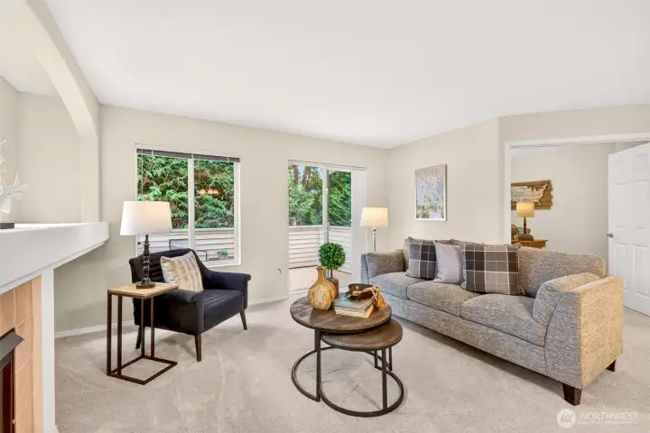The light-filled living room offers a comfortable place to relax, with a slider opening to the deck for an easy indoor-outdoor connection. Windows on two walls and treed views create a bright, restful retreat.