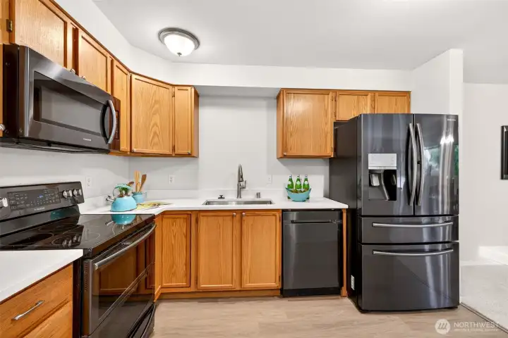 Ample oak cabinetry and counter space give this kitchen real workability, complemented by stainless appliances and bright quartz surfaces. Everything stays within easy reach, making everyday cooking and entertaining a pleasure.