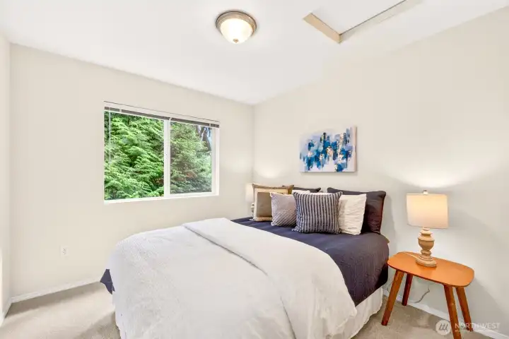 This restful bedroom enjoys a leafy green outlook and a calm, neutral palette that makes it an easy place to unwind. New carpet adds warmth and comfort underfoot.