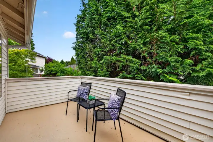 The large private deck opens to a lush wall of evergreens, creating a peaceful outdoor escape for morning coffee or unwinding at the end of the day. It extends the living space outdoors with a quiet, green backdrop.