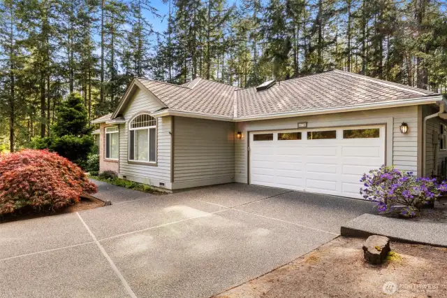 2 car garage and walkways to both sides of the home. Flowers and trees in bloom!