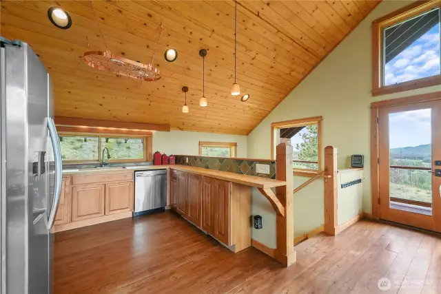 Natural wood finishes and a warm, rustic interior.  Seamless flow from kitchen to dining and outdoor balcony.