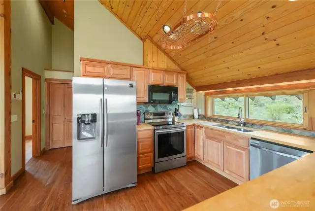Expansive picture window frames stunning outdoor views above the sink.