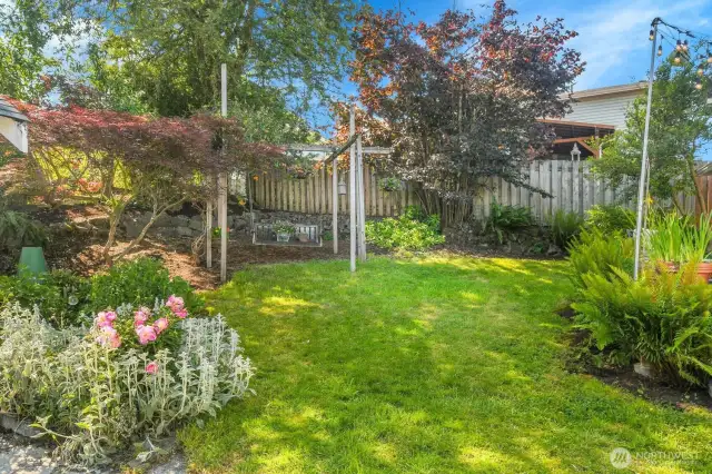 It's a little slice of paradise in the back. Lots of flowers. A little green grass. It's a perfect spot to relax.