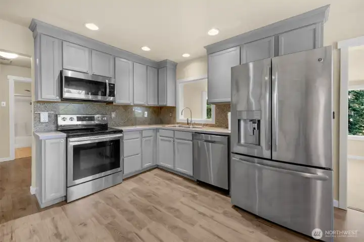 Kitchen with stainless steel appliances, and new floors
