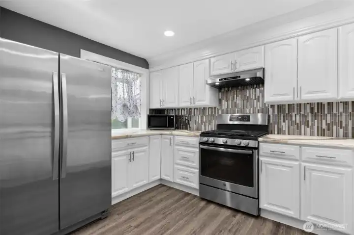 Beautiful backsplash with stainless steel appliances and gas range