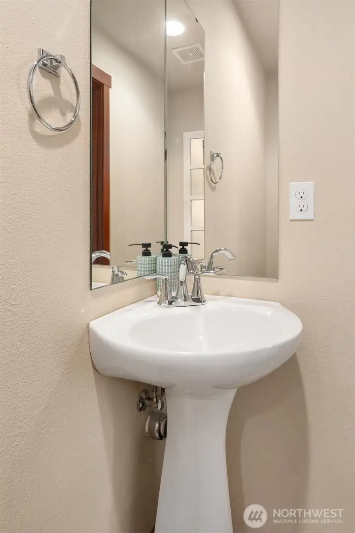 Elegant pedestal sink graces the main floor half bath.