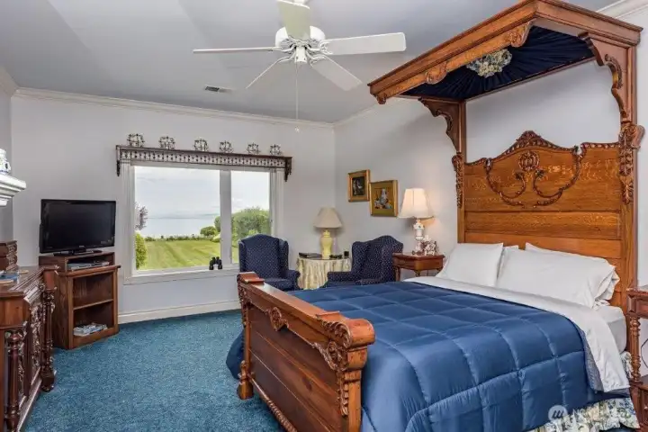 This bedroom offers a commanding view of the yard and water. Wake up to breathtaking seaside scenery.
