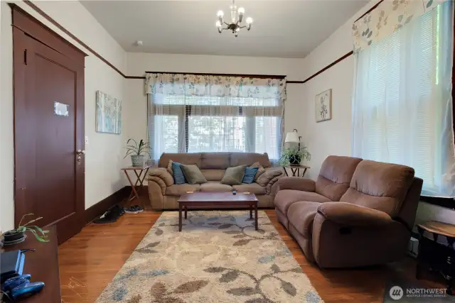 Unit A living room with large windows, it is at the front of the house.
